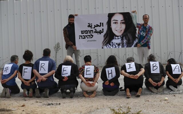 Les activistes israéliens manifestent en solidarité avec la jordanienne Heba al-Labadi (portrait), actuellement détenue en Israël et en grève de la faim, aux abords de la prison d'Ofer, en Cisjordanie, le 28 octobre 2019 (Crédit : AHMAD GHARABLI / AFP)