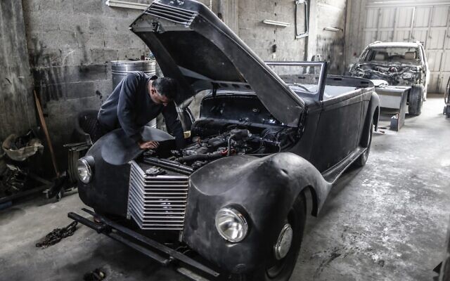 Munir Shindy, un Gazaoui de 40 ans, restaure des voitures de collections, ici une Armstrong Siddeley de 1946, le 8 octobre 2019. (Crédit : MAHMUD HAMS / AFP)