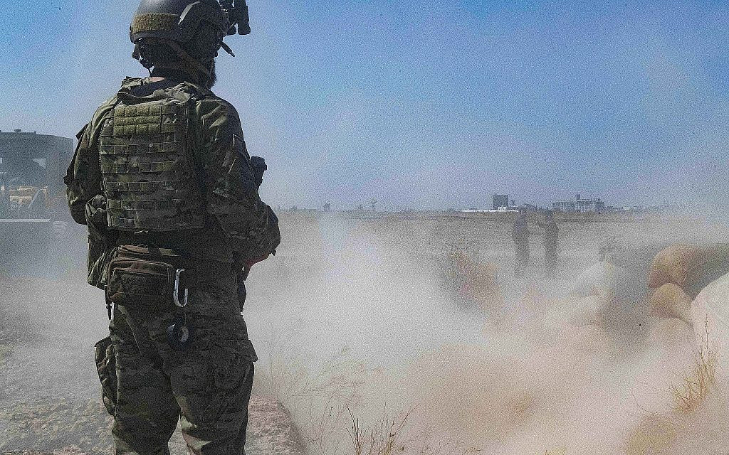 Un soldat américain supervise des membres des Forces démocratiques syriennes alors qu'ils démolissent une fortification de combattants kurdes dans le cadre de ce qu'on appelle la "zone de sécurité" près de la frontière turque, le 21 septembre 2019. (Armée américaine/Sergent d'état-major Andrew Goedl via AP)