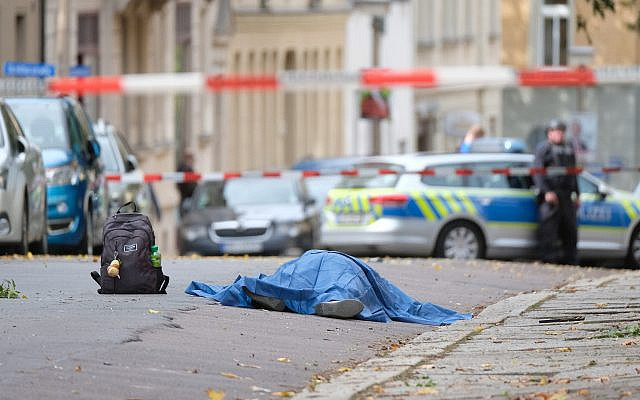 Un corps repose sur une route à Halle, en Allemagne, le 9 octobre 2019. (Crédit : Sebastian Willnow / dpa via AP)