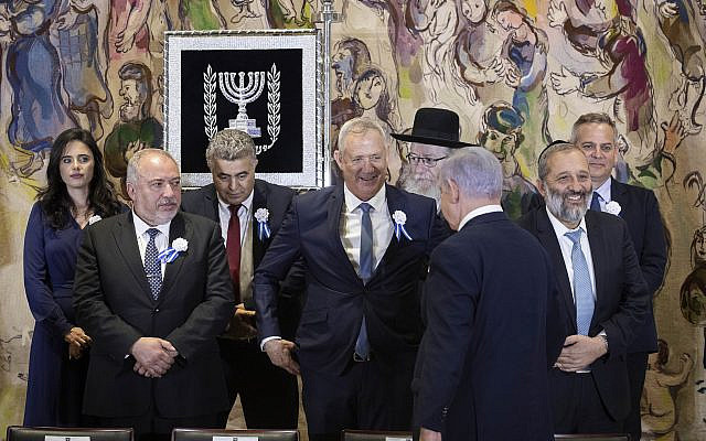 Le Premier ministre Benjamin Netanyahu (de dos) se dirige vers son rival Benny Gantz (au centre) alors qu'ils se préparent à poser pour une photo de groupe lors de la prestation de serment de la 22e Knesset à Jérusalem, le 3 octobre 2019, avec d'autres chefs de parti dont Avigdor Liberman (à gauche) et Aryeh Deri (à droite). (Hadas Parush/Flash90)