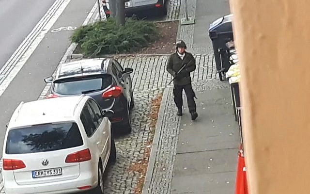 Un homme armé tire dans une rue de Halle, en Allemagne, après une fusillade devant une synagogue dans la même ville, faisant deux morts. (Crédit : capture d'écran / Andreas Splett / ATV-Studio Halle / AFP)