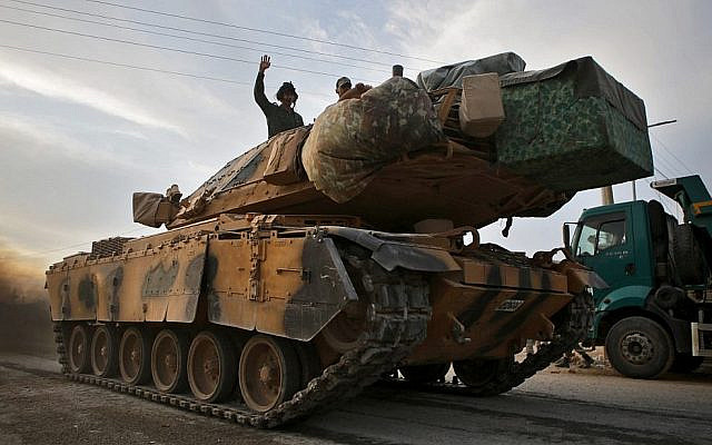 Des soldats turcs et des combattants syriens soutenus par la Turquie sur un tank de l'armée turque à proximité du village turc d'Akcakale le long de la frontière avec la Syrie, le 11 octobre 2019, alors qu'il se préparent à prendre part à un assaut mené par la Turquie dans le nord-est de la Syrie.
(Bakr ALKASEM / AFP)