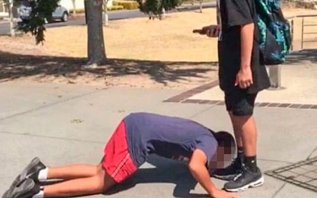 Une photo montrant un garçon juif qui aurait été forcé à embrasser les pieds d'un camarade de classe entraîne un tollé en Australie. (Twitter via le JTA)