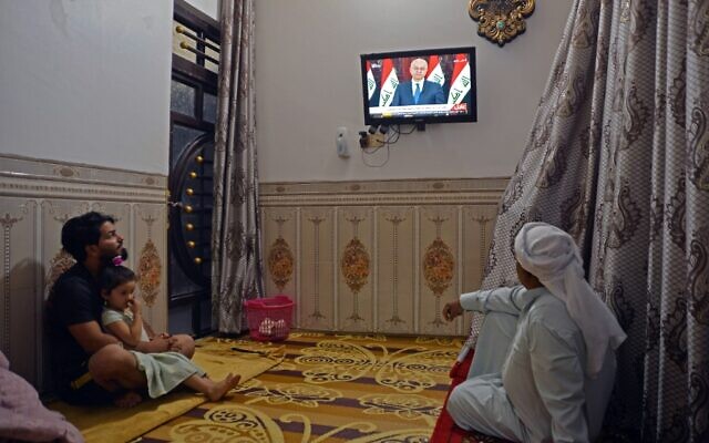 Des Irakiens écoutent un discours télévisé du président Barham Saleh à Najaf, le 31 octobre 2019. (Crédit : Haidar HAMDANI / AFP)