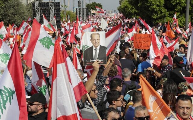 Un soutien du président libanais Michel Aoun brandit sa photo lors d'une contre manifestation à proximité du palais présidentiel, le 3 novembre 2019. (Photo par ANWAR AMRO / AFP)