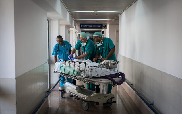 Photo d'illustration : Des médecins et des infirmières soignent un malade au centre médical Wolfson de Holon (Crédit : Hadas Parush/Flash90)