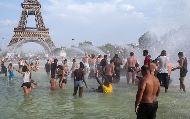 Des Français se rafraîchissent dans les fontaines des jardins du Trocadéro, à Paris, le 25 juillet 2019, pendant un épisode de canicule. (Crédit : AP Photo/Rafael Yaghobzadeh)