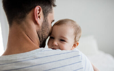 Illustration : Un père tenant dans ses bras sa petite fille à la maison. (Crédit: Wavebreakmedia ; iStock by Getty Images)