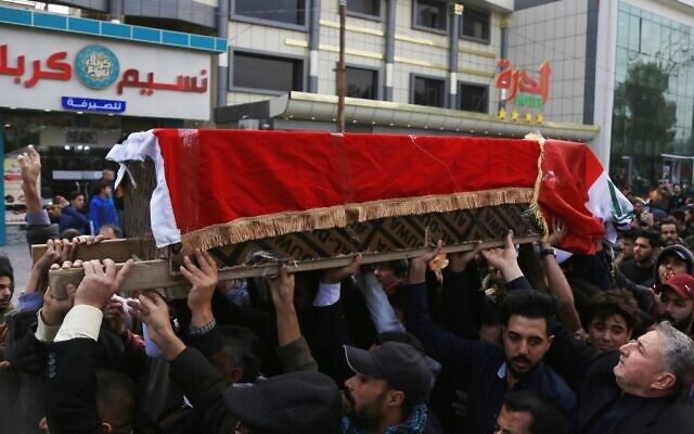 Des Irakiens portent le cercueil d'un éminent militant de la société civile qui a été abattu la nuit précédente alors qu'il rentrait chez lui après des manifestations antigouvernementales, lors de ses funérailles à Karbala, une ville sanctuaire irakienne, le 9 décembre 2019, au sud de la capitale Bagdad.. (Crédit : Mohammed SAWAF / AFP)