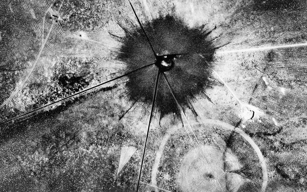 Ceci est une vue aérienne des conséquences de la première explosion atomique au site d'essai de Trinity, au Nouveau-Mexique, le 16 juillet 1945.  Elle a laissé un cratère de 800 mètres de large, 3 mètres de profondeur au niveau de sa cheminée et le sable se trouvant dans le cratère a été brûlé et bouilli dans une croûte vitreuse, vert jade, très radioactive. (AP Photo)