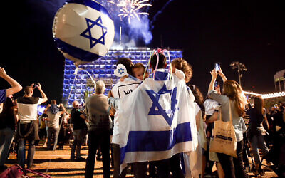 Des Israéliens devant des feux d'artifice à la mairie de Tel Aviv, le 18 avril 2018, à l’occasion du 70e jour de l'indépendance d'Israël. (Crédit : Miriam Alster / Flash90)