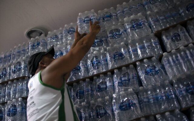 Un homme achète de l'eau en bouteille dans un magasin d'alcool du quartier de Lapa à Rio de Janeiro, le 15 janvier 2020. (Crédit : Mauro Pimentel / AFP)
