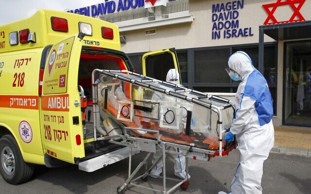Des secouristes de la Magen David Adom, l'équivalent de la Croix-Rouge en Israël, simulent le transport d'une personne atteinte du nouveau coronavirus, à Kyriat Ono, à l'est de Tel-Aviv, le 26 février 2020. (Crédit : AFP
JACK GUEZ / AFP)