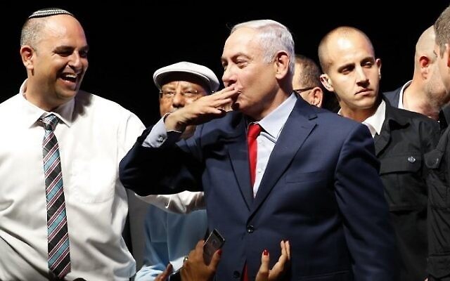 Le Premier ministre Benjamin Netanyahu, (au centre), envoie un baiser à la foule alors qu'il est entouré de militants lors d'un rassemblement pour lui témoigner son soutien alors qu'il est confronté à des enquêtes de corruption, qui s'est tenu au Tel Aviv Convention Center, le 9 août 2017. (AFP/Jack GUEZ/File)