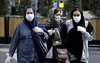 Des gens portent des masques pour se protéger du coronavirus dans une rue du centre-ville de Téhéran, en Iran, le 23 février 2020. (Ebrahim Noroozi/AP)