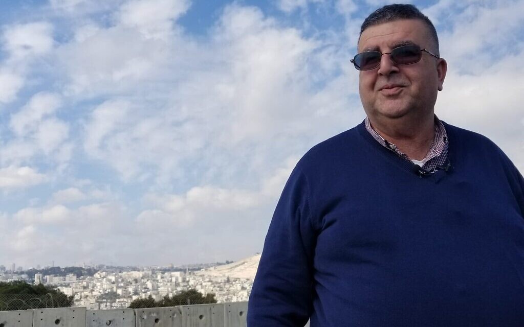 Le maire Ahmad Abu Hilal sur le toit d'un bâtiment à côté de la barrière de sécurité à Abu Dis, le 3 février 2020. (Adam Rasgon/Times of Israel)