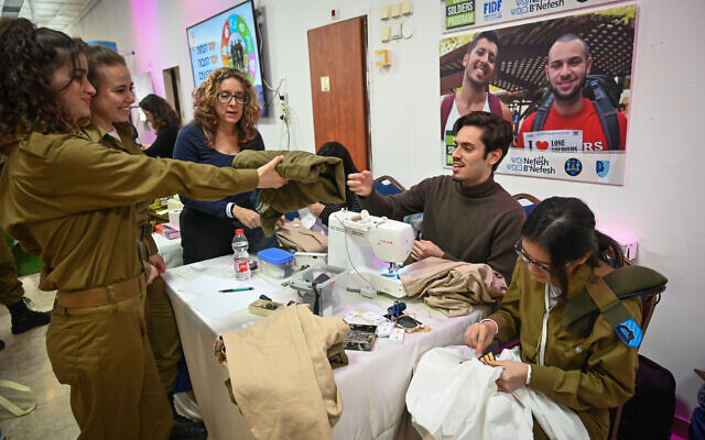 Un soldat seul de Tsahal tend à un tailleur une paire de pantalon lors de l'événement annuel "Jour de Commissions" à Tel Aviv, le 13 février 2020.  (Shahar Azran/Nefesh B’Nefesh)