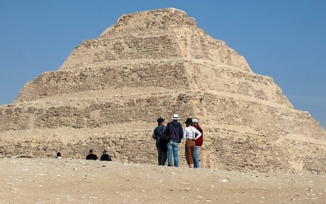 Des visiteurs observent la pyramide de Djoser dans la nécropole égyptienne de Saqqara, au sud de la capitale du Caire, le 5 mars 2020. (Photo par Mohamed el-Shahed / AFP)
