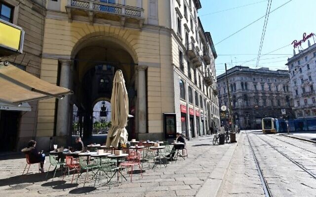 Des touristes à la terrasse d'un café dans la Via Orefici dans le centre de Milan, le 8 mars 2020, après la mise en quarantaine forcée de millions de personnes dans le nord de l'Italie. (Crédit : MIGUEL MEDINA / AFP)