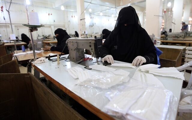 Une femme yéménite fabrique des masques dans une usine textile de la capitale Sanaa, le 16 mars 2020, en pleine pandémie de coronavirus. (Crédit :  Mohammed HUWAIS / AFP)
