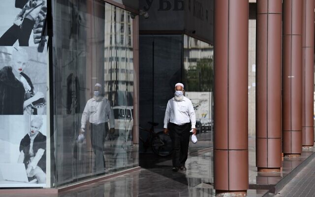 Un homme portant un masque de protection dans une rue de Dubaï, aux Emirats arabes unis, le 18 mars 2020. (Crédit : KARIM SAHIB / AFP)