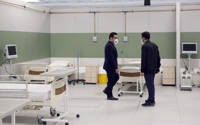 Du personnel iranien met en place un hôpital improvisé à l'intérieur d'un centre commercial iranien dans le nord ouest de Téhéran , le 21 mars 2020 en pleine crise du coronavirus. (Photo par STR / AFP)