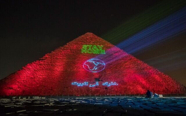Spectacle lumineux sur la pyramide de Guizeh appelant le monde à se confiner, en pleine pandémie de coronavirus, le 30 mars 2020. (Crédit : Khaled DESOUKI / AFP)