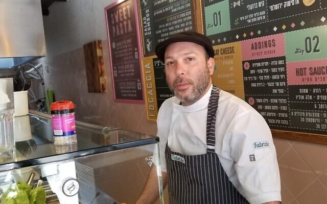 Ofir Manshari, 39 ans, propriétaire du restaurant de pâtes Fabrizio, derrière son comptoir, dans le centre de Tel Aviv, le 15 mars 2020. (Adam Rasgon/Times of Israel)