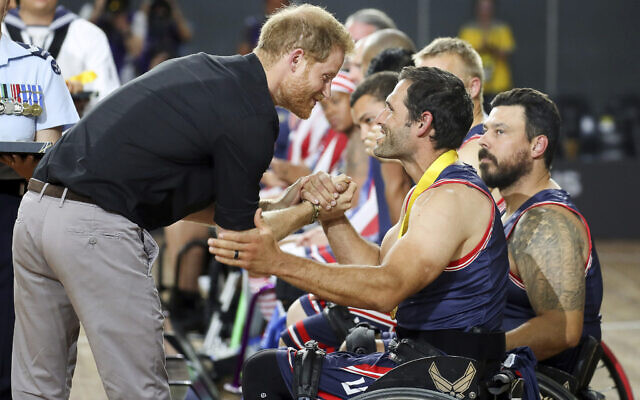 Le prince Harry de Grande-Bretagne félicite un membre de l'équipe américaine de basket-ball en fauteuil roulant après avoir remporté la médaille d'or lors de la huitième journée des Invictus Games à Sydney, en Australie, le 27 octobre 2018. (Crédit : Chris Jackson/AP)