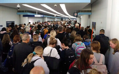 Des voyageurs font la queue pour passer la douane à l'aéroport international O'Hare de Chicago, le samedi 15 mars 2020. (Crédit : AP Photo/Michael Sadler)