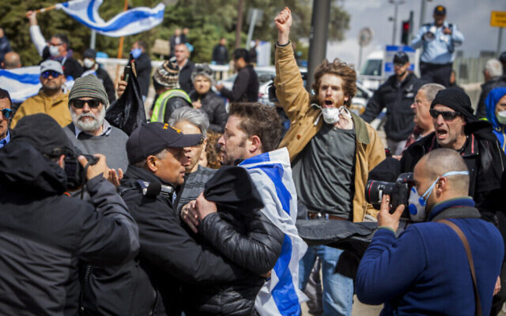 Le police israélienne aux prises avec un homme pendant une manifestation pour "sauver la démocratie" aux abords de la Knesset à Jérusalem, le 19 mars 2020. (Crédit : AP Photo/Eyal Warshavsky)