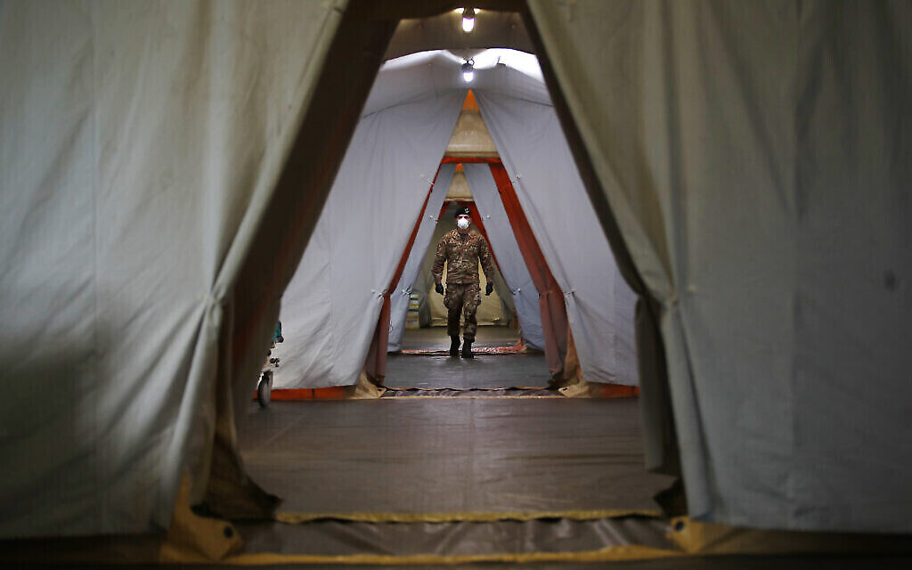 Un soldat italien entre dans l'hôpital de campagne construit à Crema, en Italie, le mardi 24 mars 2020. (AP Photo/Antonio Calanni)