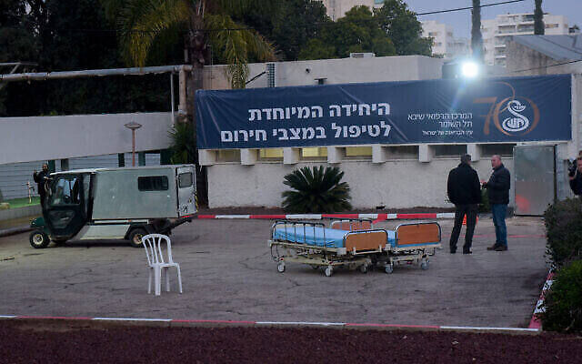 Des employés de l'hôpital Sheba-Tel HaShomer devant un bâtiment transformé en unité de confinement pour le coronavirus, le 20 février 2020. (Crédit : Avshalom Sassoni/Flash90)