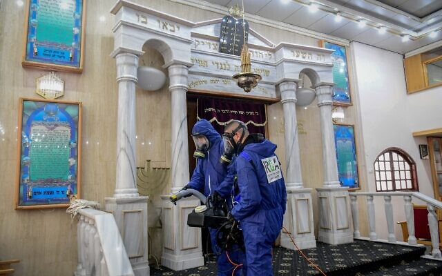 Des agents portant des vêtements de protection désinfectent une synagogue à Bat Yam, le 18 mars 2020, dans le cadre des mesures visant à prévenir la propagation du coronavirus. (Flash90)