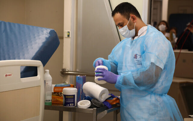Un employé prépare des médicaments à l'hôpital Ichilov de Tel Aviv pour des personnes infectées par le coronavirus, le 19 mars 2020. (Crédit : Flash90)