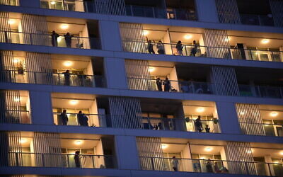 Les habitants de Tel Aviv sur leurs balcons, applaudissent les soignants mobilisés pour la lutte contre le coronavirus, le 19 mars 2020. (Crédit : Tomer Neuberg/Flash90)