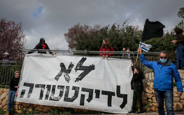 Des manifestants s'insurgent contre la décision du président de la Knesset, Yuli Edelstein, d'interdire les réunions du plénum de la Knesset, portant un panneau indiquant "Non à la dictature" devant la Knesset à Jérusalem, le 19 mars 2019. (Yonatan Sindel/Flash90)