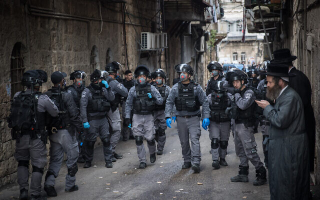 Des policiers israéliens dans le quartier juif ultra orthodoxe de Meah Shearim fermant des magasins et dispersant des rassemblements publics suite aux décisions du gouvernement dans le but de contenir la propagation du coronavirus, le 22 mars 2020. (Crédit : Yonatan Sindel/Flash90)