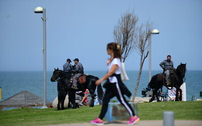 La police israélienne sur la promenade de la plage de Tel-Aviv le 23 mars 2020. La police a été envoyée dans tout le pays pour empêcher les gens de se rassembler dans les espaces publics afin de contenir la propagation du coronavirus. (Crédit : Tomer Neuberg/Flash90)