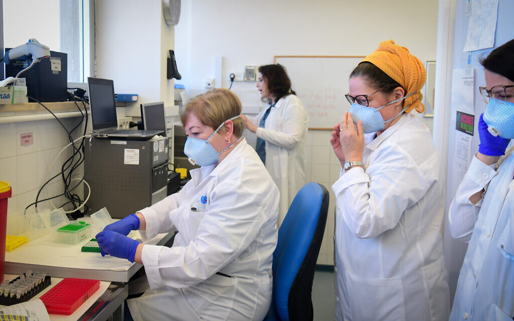 Les membres de l'équipe médicale de l'hôpital Barzilay, dans la ville d'Ashkelon, au sud d'Israël, portent des équipements de protection, alors qu'ils manipulent un échantillon de test de Coronavirus le 29 mars 2020. (Crédit : Flash90)