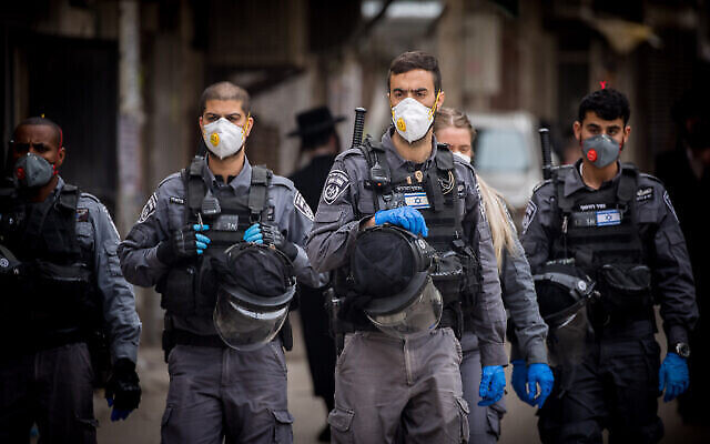 Des agents de police ferment des synagogues et dispersent des rassemblements publics dans le quartier juif orthodoxe de Mea Sharim à Jérusalem, le 31 mars 2020 (Crédit : Yonatan Sindel/Flash90)