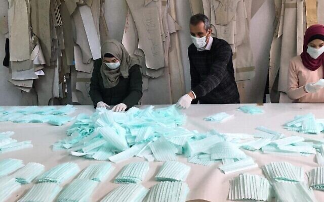 Les employés d'une usine de Hébron fabriquent des masques pour le marché palestinien (Autorisation : Amjad Zughayir)