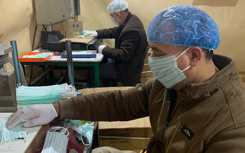 Les employés d'une usine de Hébron fabriquent des masques pour le marché palestinien en Cisjordanie (Autorisation : Amjad Zughayir)