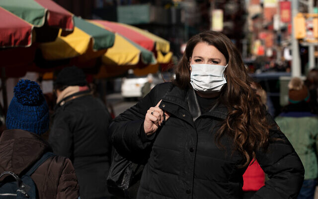 Une femme porte un masque pour se protéger du coronavirus à New York, le 30 janvierr 2020. (Crédit : AP/Mark Lennihan)
