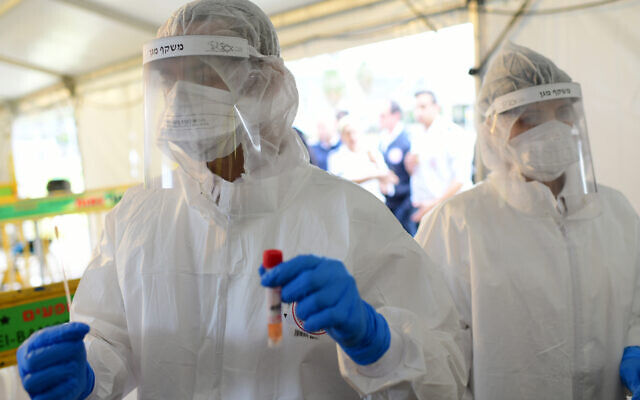 Des employés du Magen David Adom collectent des échantillons de tests au coronavirus à Tel Aviv, le 20 mars 2020. (Crédit : Tomer Neuberg/Flash90)