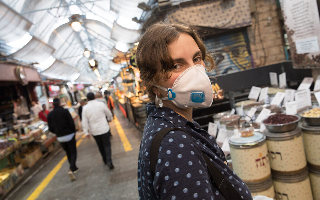 Une femme porte un masque pour se protéger du coronavirus au marché Mahane Yehuda, à Jérusalem, le 15 mars 2020. (Nati Shohat/Flash90)