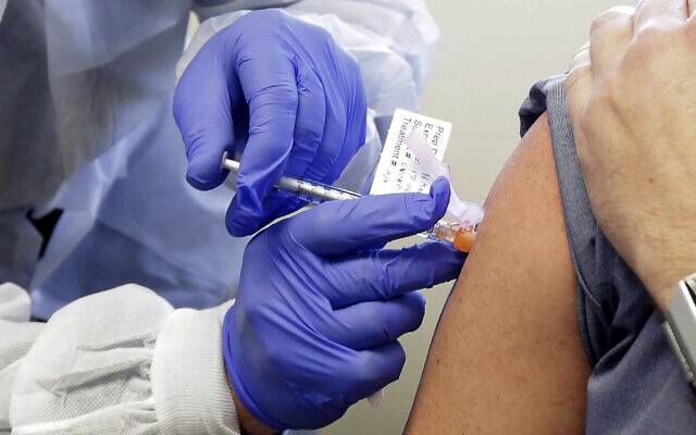 Un homme reçoit une première injection dans la première phase d'essai clinique d'un potentiel vaccin pour le Covid-19, la maladie causée par le nouveau coronavirus, le lundi 16 mars 2020, au 
Kaiser Permanente Washington Health Research Institute à Seattle (AP Photo/Ted S. Warren)