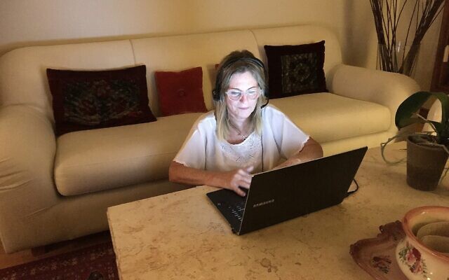 Odi Gruber, une volontaire d'ERAN, portant un casque dans sa maison de Toronto, où elle est volontaire pour prendre des appels d'Israël par son ordinateur. (Robert Sarner/ Times of Israël)