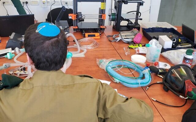 Un soldat de l'unité technologique du renseignement militaire travaille sur un projet de conversion d'appareils CPAP en ventilateurs respiratoires afin d’aider à la lutte contre la pandémie de coronavirus, en mars 2020. (Crédit : Armée israélienne)